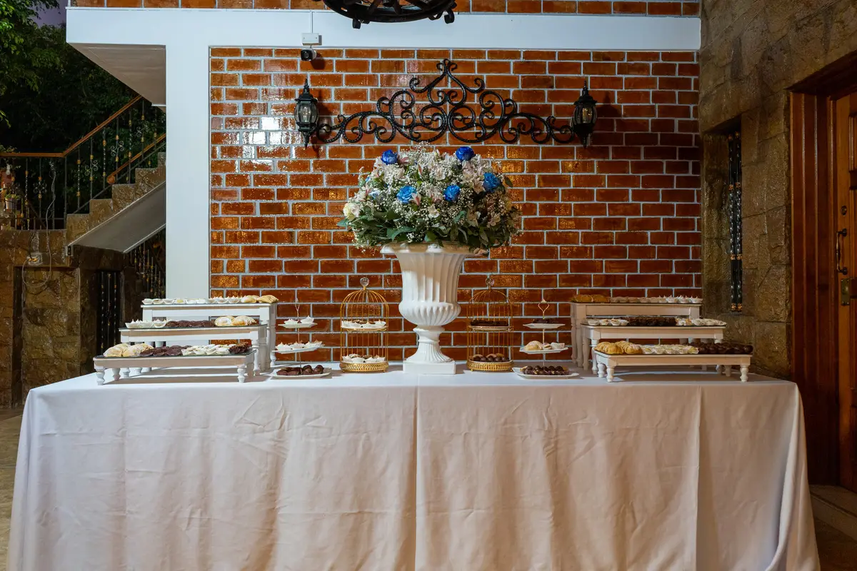 Estación de buffet con fuentes térmicas de acero sobre una mesa con mantel blanco