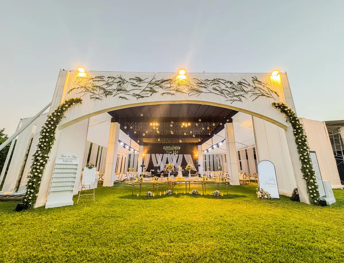 Entrada al toldo decorada con flores y follaje para recibir a los invitados