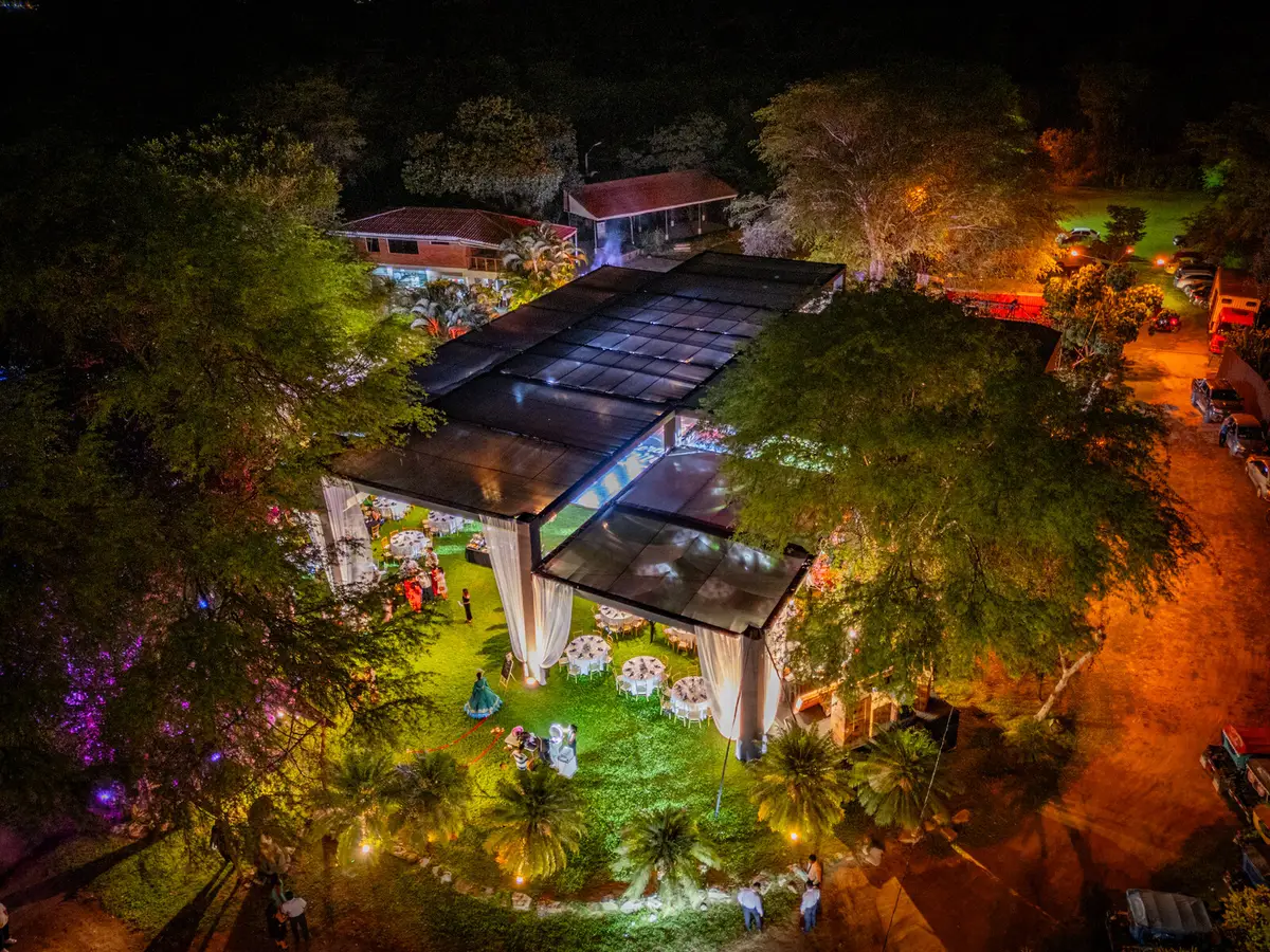 Vista aérea del evento entre jardines, árboles y luces cálidas