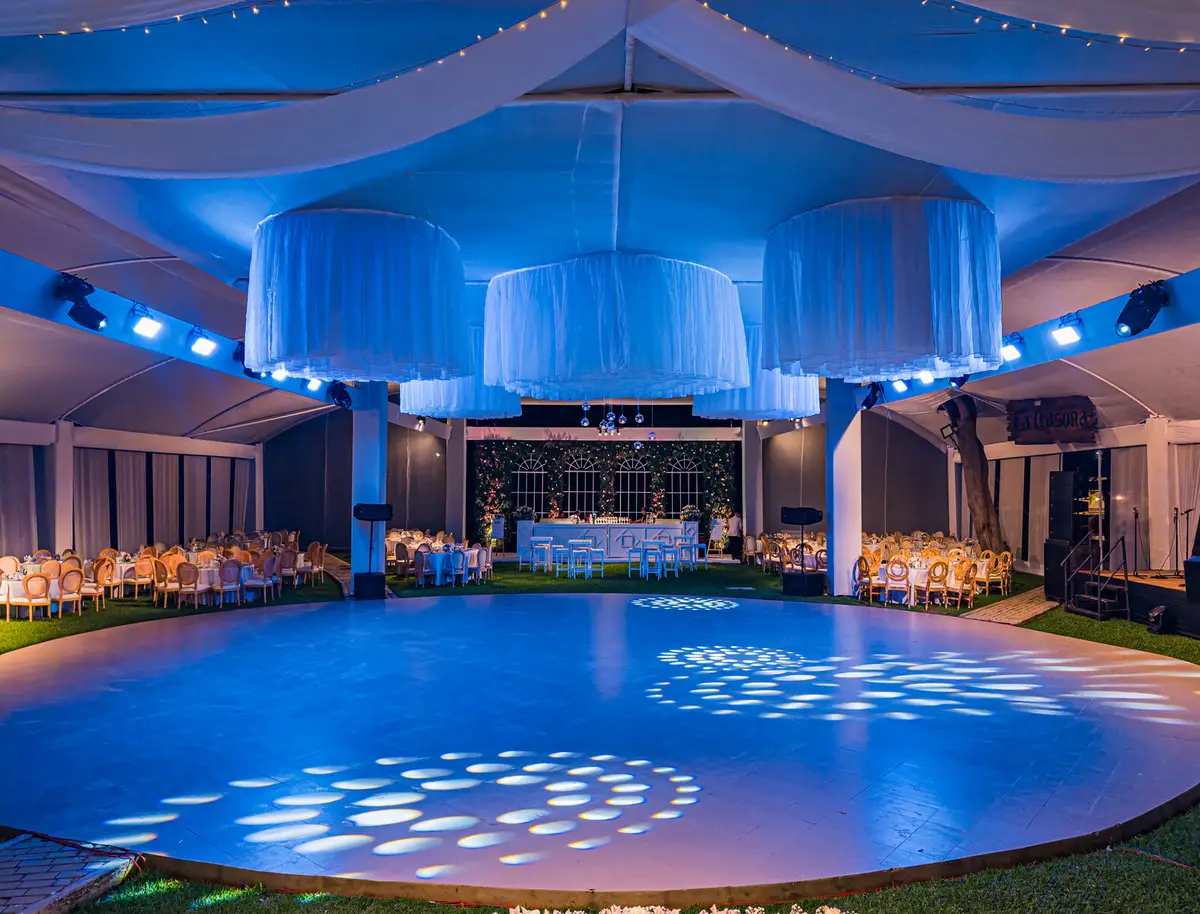 Pista iluminada en azul bajo un toldo, lista para celebrar