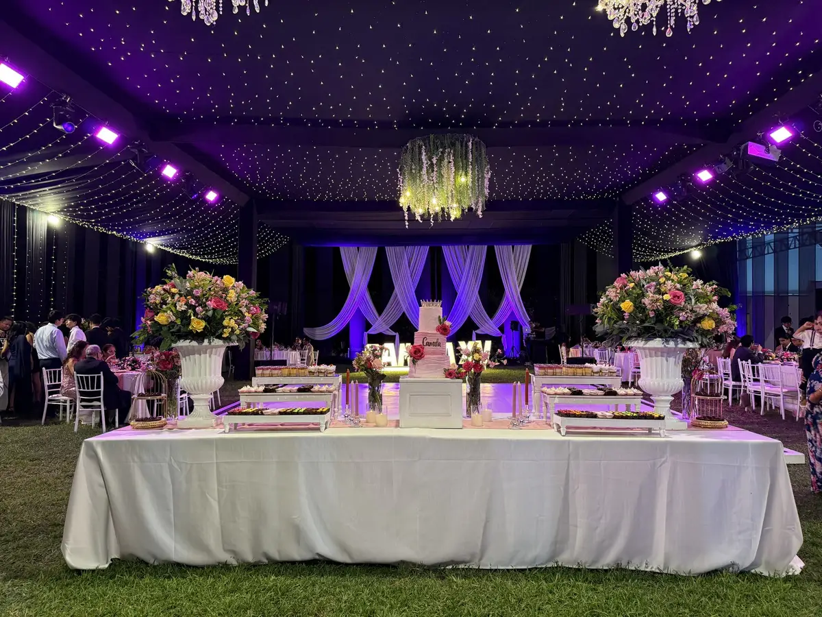 Mesa principal y salón de recepción bajo un toldo iluminado