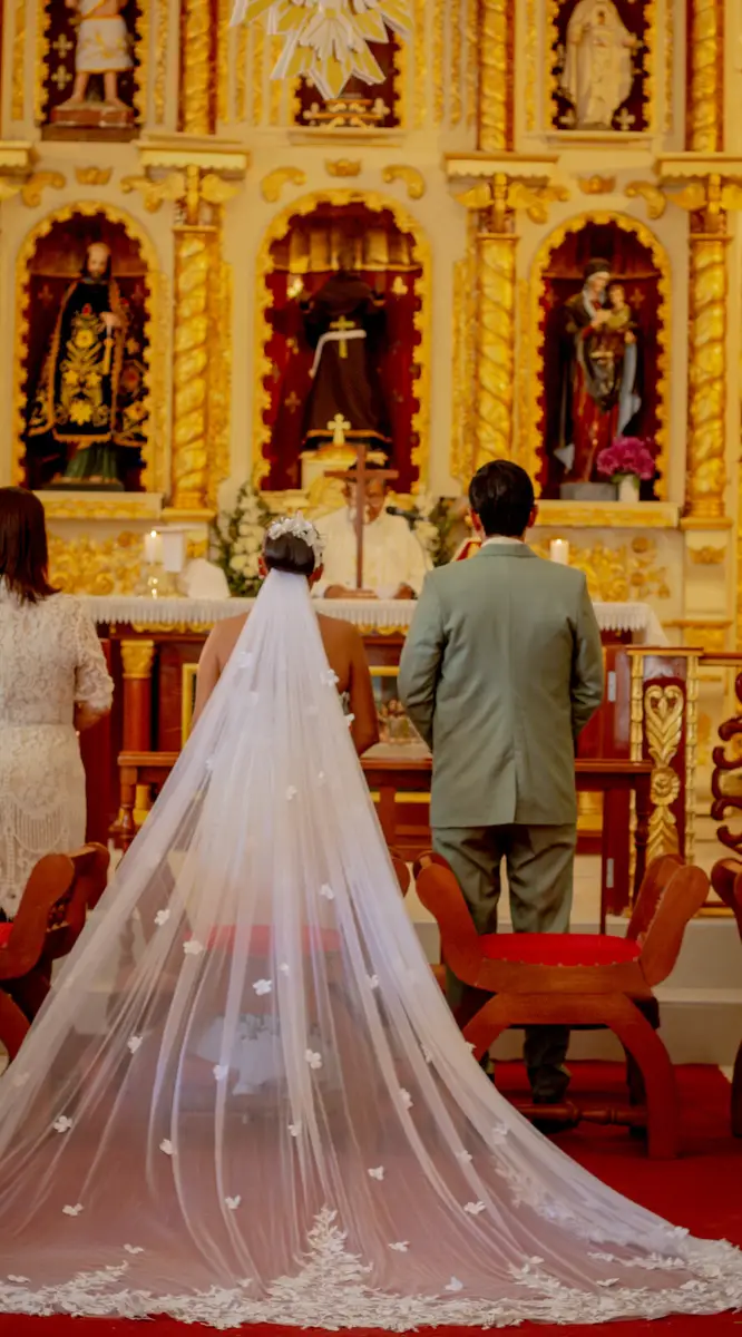 La novia avanza hacia el altar con un largo velo
