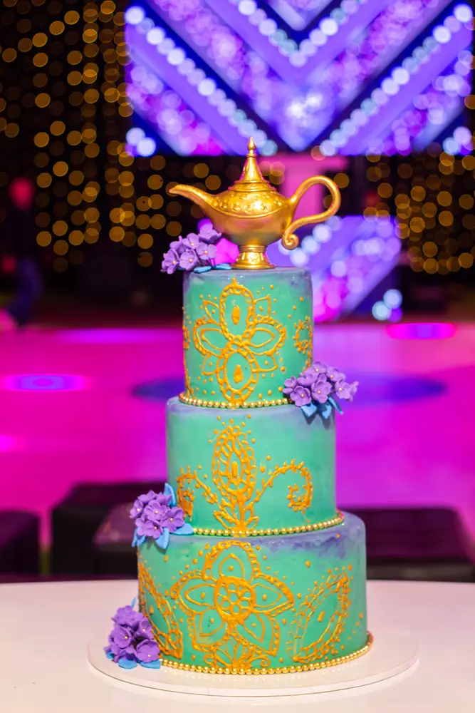 Torta turquesa con detalles dorados y una lámpara decorativa