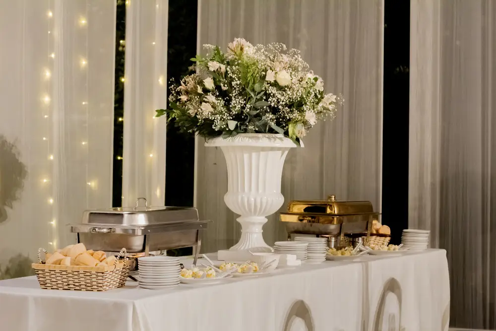 Mesa de bocaditos con flores y decoración elegante