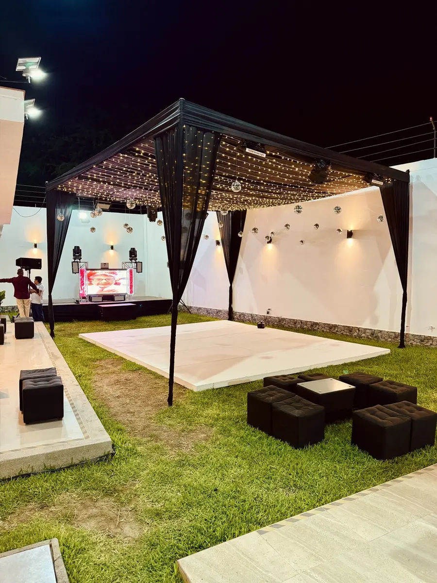 Toldo iluminado de noche con pista y zona lounge