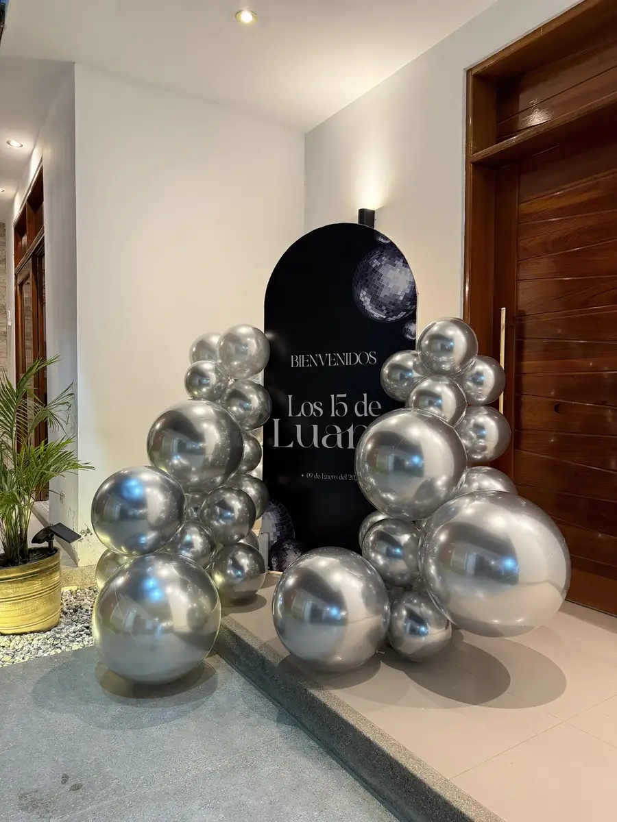 Bienvenida festiva con globos plateados y un cartel personalizado